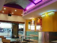 curved ceiling in beaten stainless steel reflecting coloured neon lights in coves